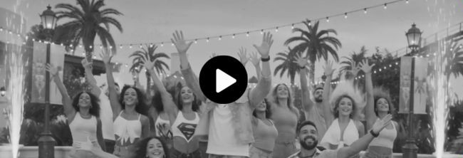 Grupo de viajeros bailando la canción oficial